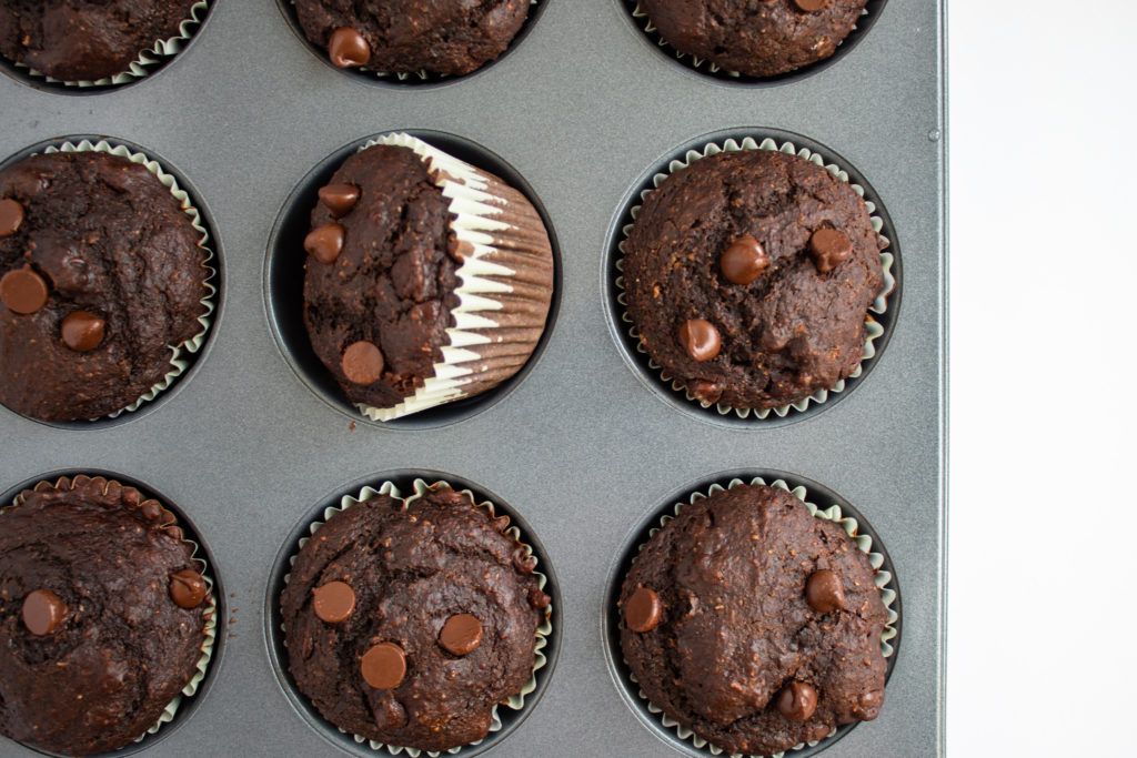 Skinny Double Chocolate Muffins in pan with one on side.