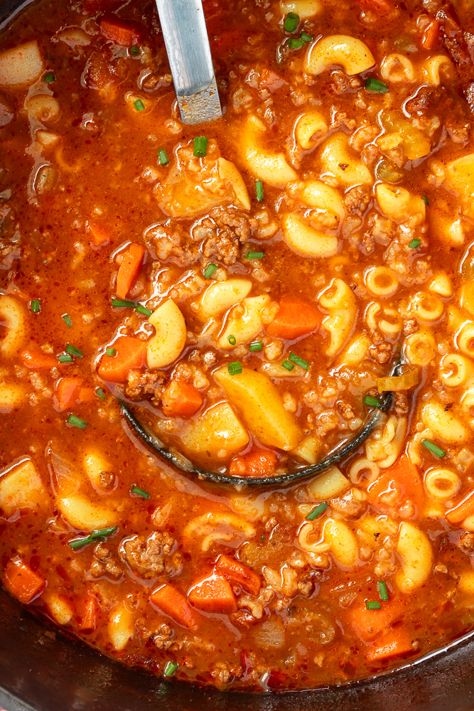 Close up overhead shot of Hamburger soup in dutch oven with ladle.