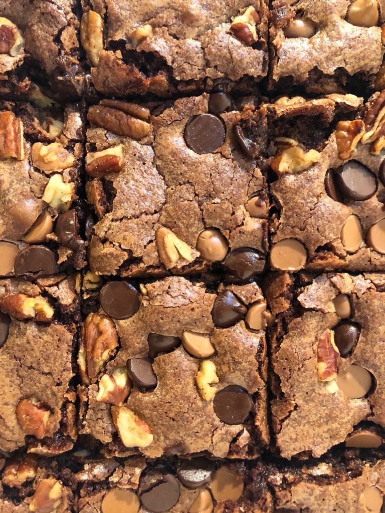 brownies cut into squares with pecans and chocolate chips on top