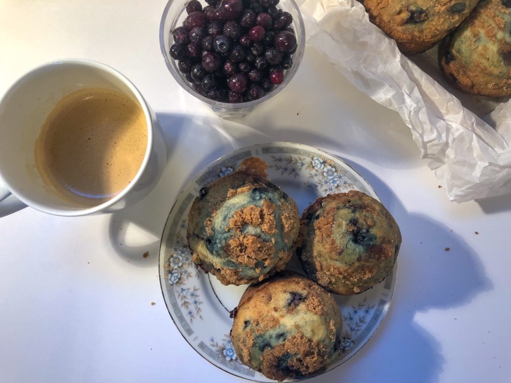 blueberry streusel muffins on plate with coffee and blueberries