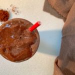 iced coffee shake with straw and cocoa powder