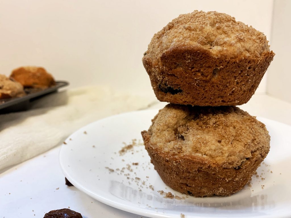 cinnamon raisin muffins with streusel stacked on top of plate