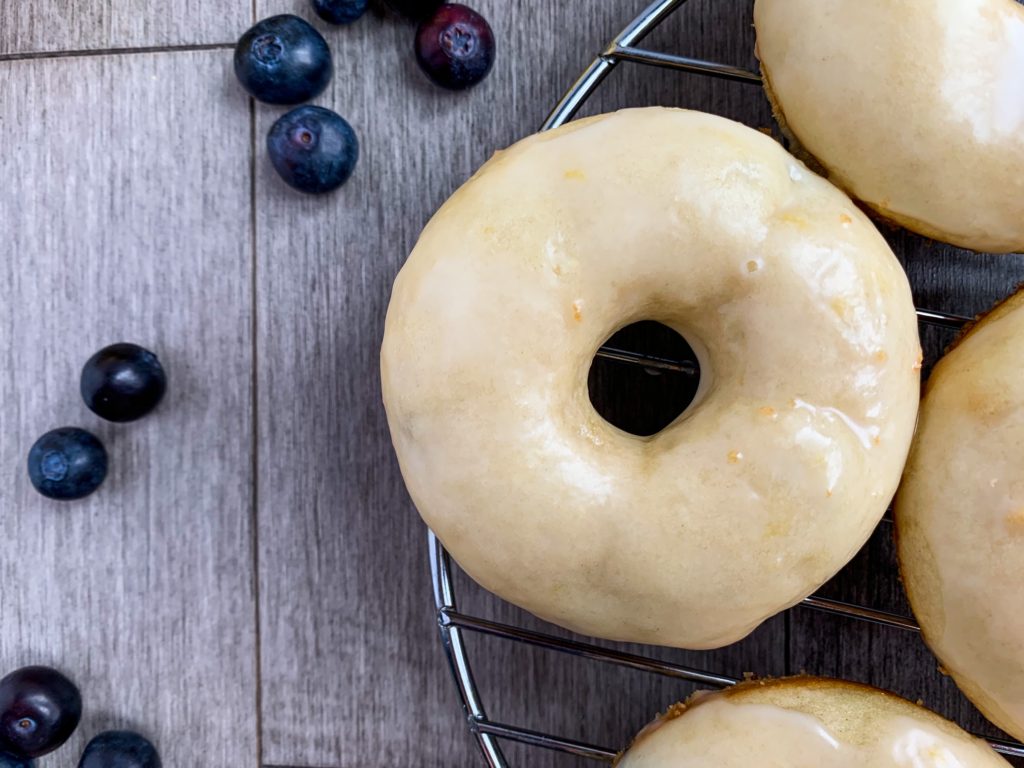 lemon glazed blueberry donuts on wire rack