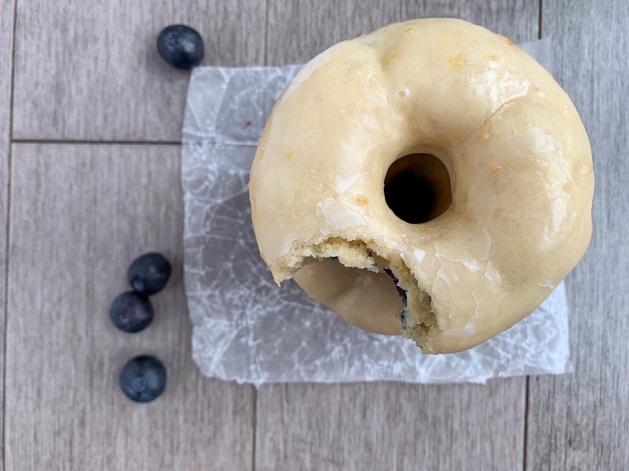 lemon glazed blueberry donut stacked on parchment