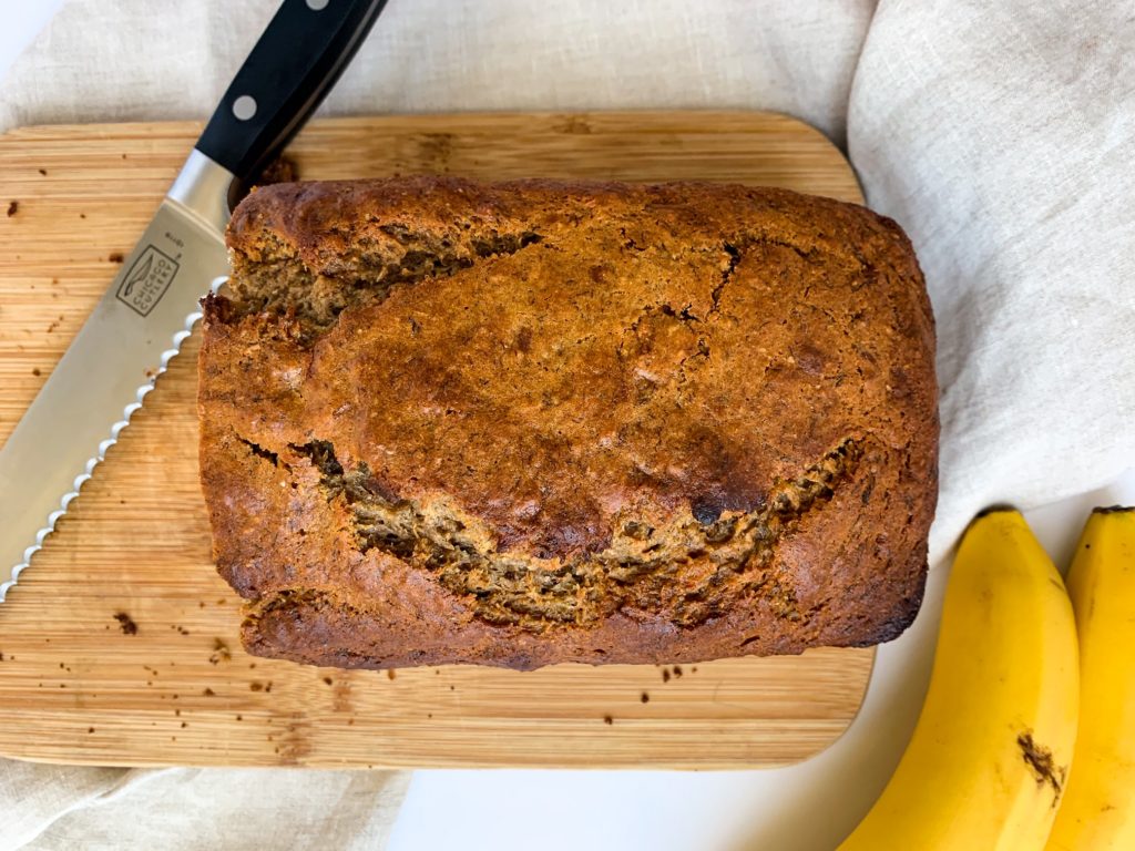 Healthy Banana Bread on cutting board with knife.