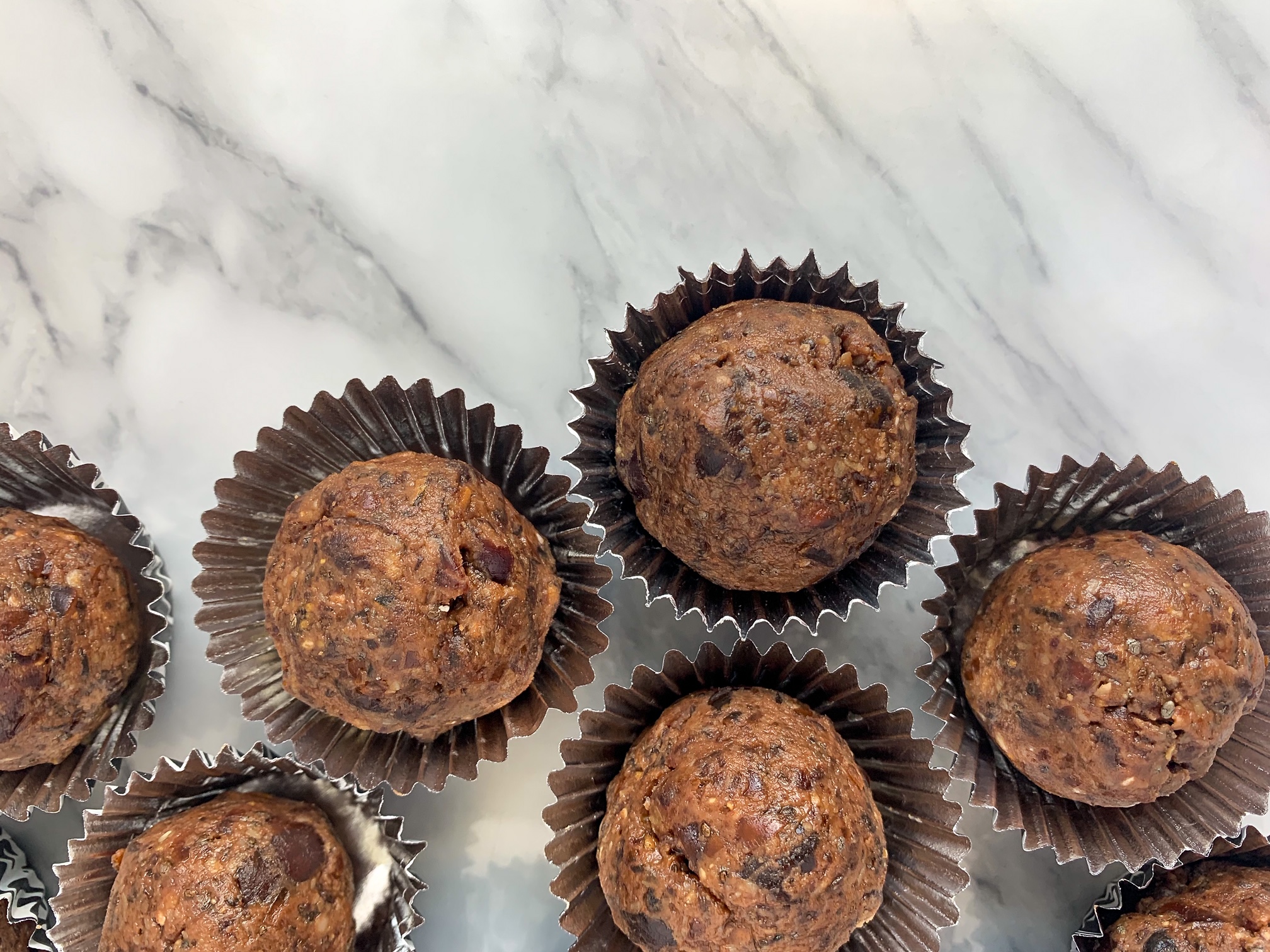 overhead shot of peanut butter date balls in mini muffin cups