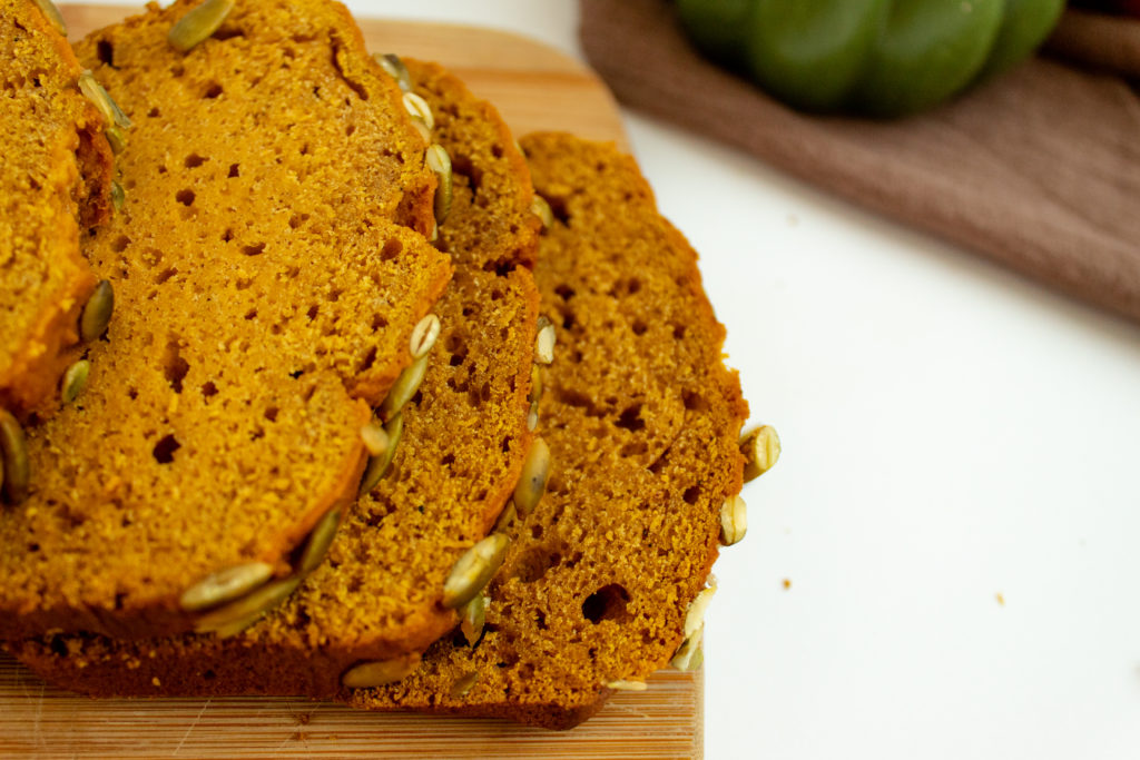 Sliced Pumpkin Bread with pepitas on top.