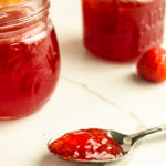 apple strawberry jam with spoonful on marble tile