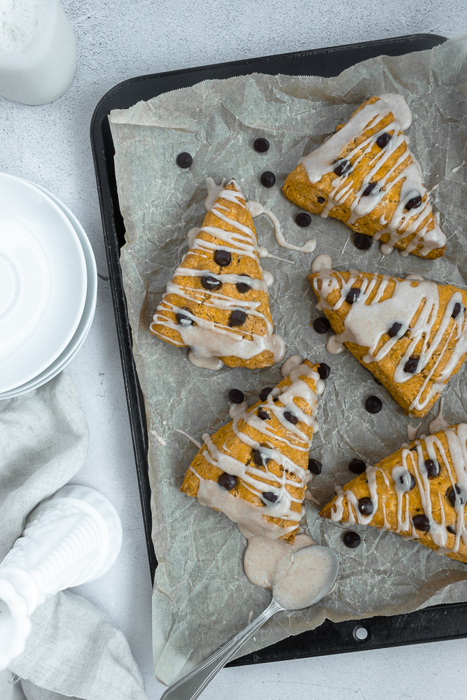 Overhead shot of pumpkin chocolate chip scones on parchment lined pan.