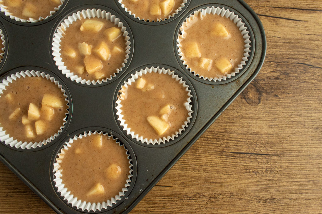 apple cinnamon muffin batter in muffin pan overhead shot