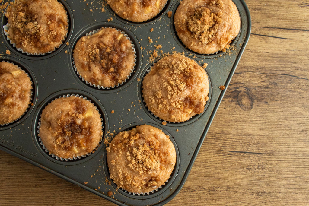 apple cinnamon streusel muffins baked in muffin pan overhead shot.