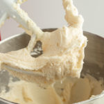 Vanilla buttercream frosting recipe in kitchen mixer with paddle attachment.