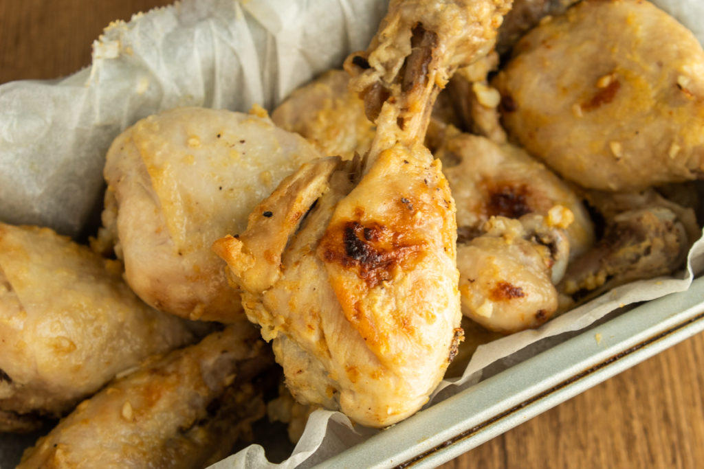 Lemon Dijon Chicken Drumsticks sitting in loaf pan with parchment paper