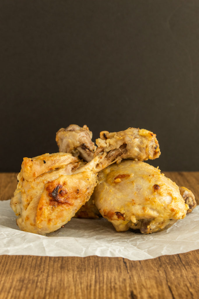 Lemon Dijon Chicken Drumsticks sitting on parchment paper straight shot.