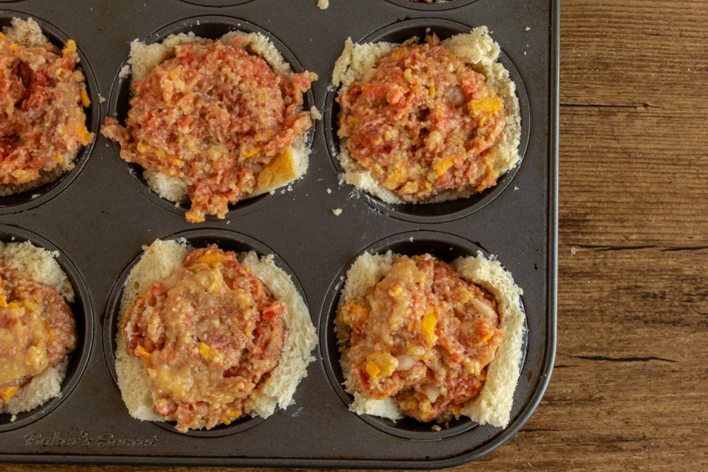 Raw Cheeseburger cupcakes in muffin pan overhead shot.