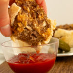 Cheeseburger cupcake being dipped in ketchup.