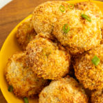 Air fryer chicken balls on plate on wood.