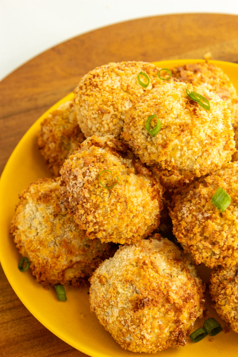 Air fryer chicken balls on plate on wood.