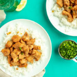 Sweet and sour chicken served over rice on plates overhead shot.