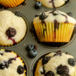 White muffins with blueberries in pan.