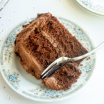 Slice of the best Chocolate layer cake overhead shot with fork on plate.