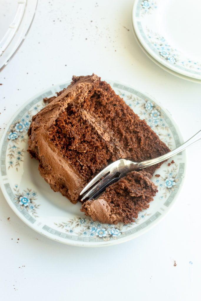 Slice of the best Chocolate layer cake overhead shot with fork on plate.