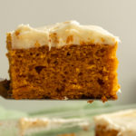 Slice of Spiced Pumpkin Cake on serving spatula in the air.