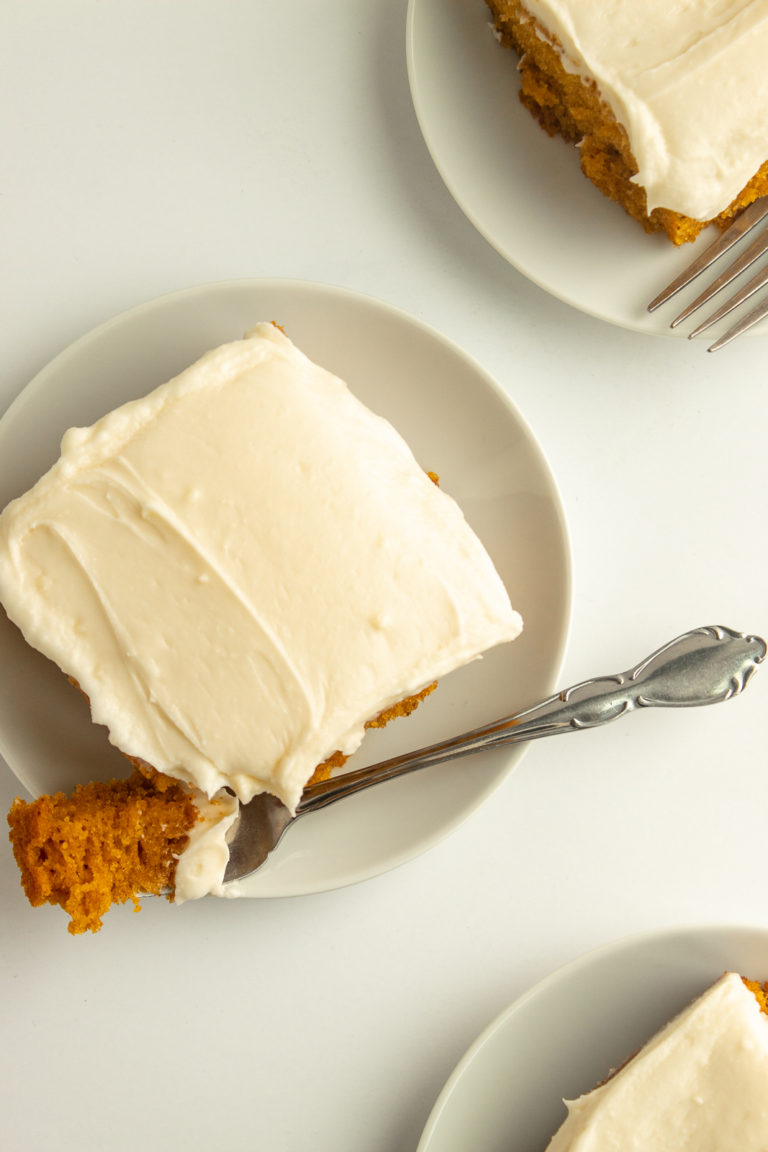 Spiced Pumpkin Cake with cream cheese frosting on plate with fork overhead shot.