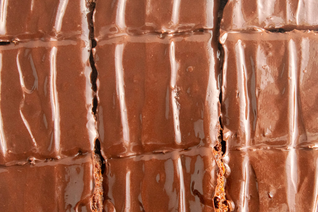 Healthy gluten free sweet potato brownies with refined sugar free icing cut up overhead shot.