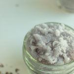 Homemade Lavender Body scrub in mason jar beside lavender buds