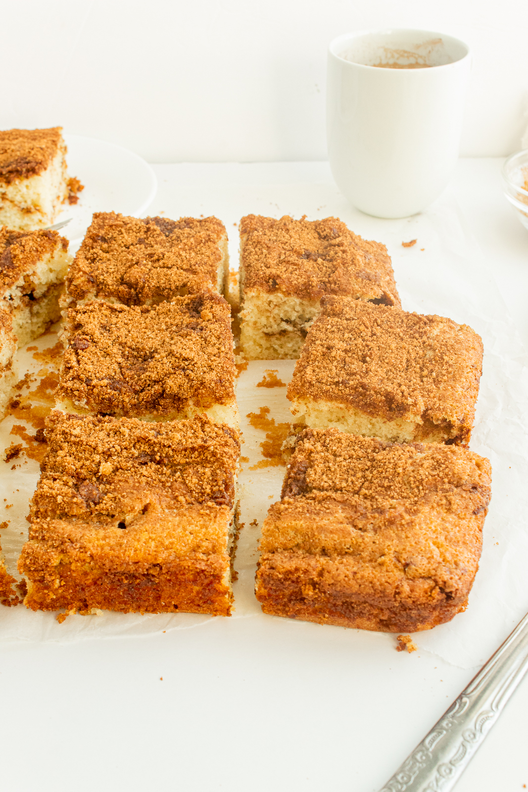 Moist Coffee Cake sliced in squares on parchment paper angled shot.