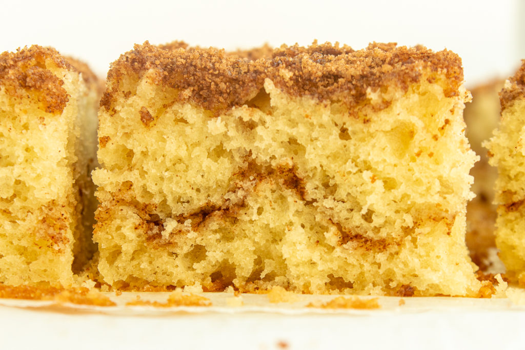 Moist Coffee Cake sliced on parchment paper straight on close up.