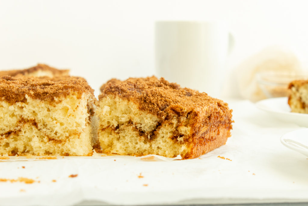 Moist Coffee Cake sliced on parchment paper straight on shot.