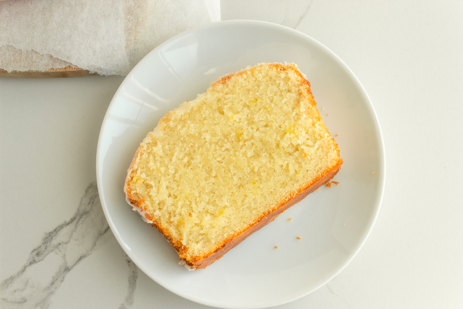 Slice of gluten free lemon loaf on plate overhead shot.