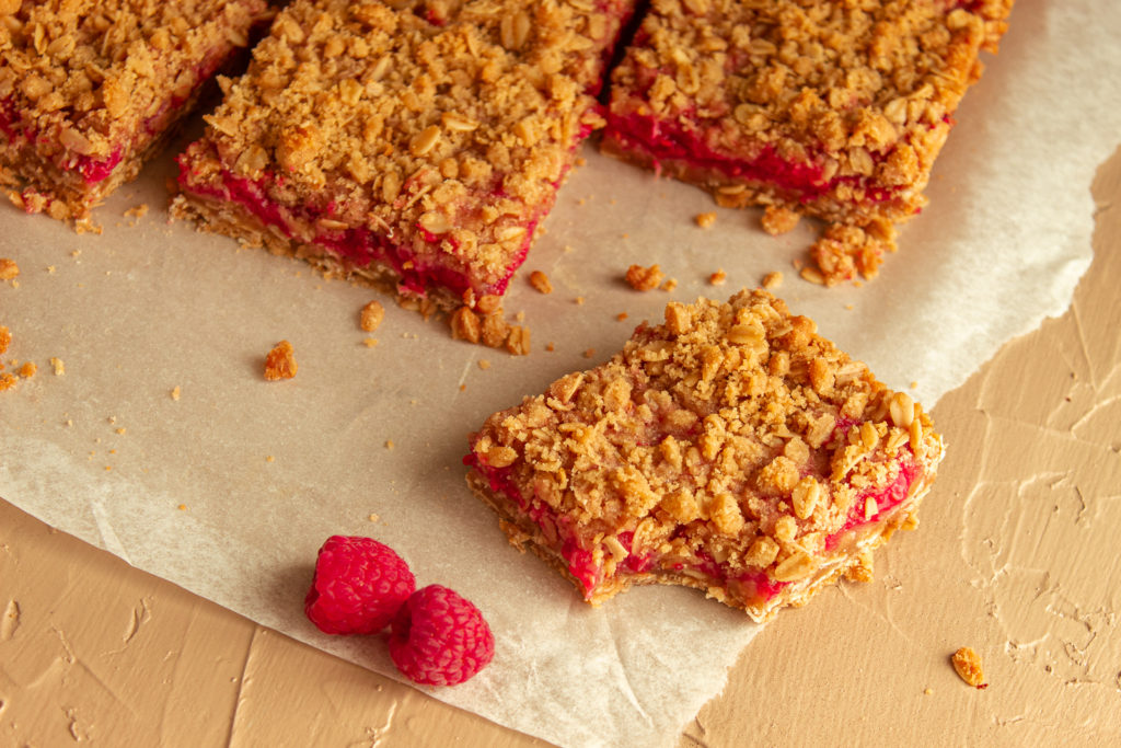 Raspberry Crumble Bars angled shot with bite.