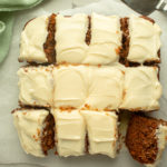 Carrot sheet cake overhead shot cut up into squares with cream cheese frosting.