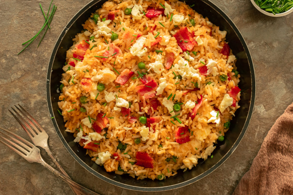 Fried rice overhead shot in frying pan on dark brown surface