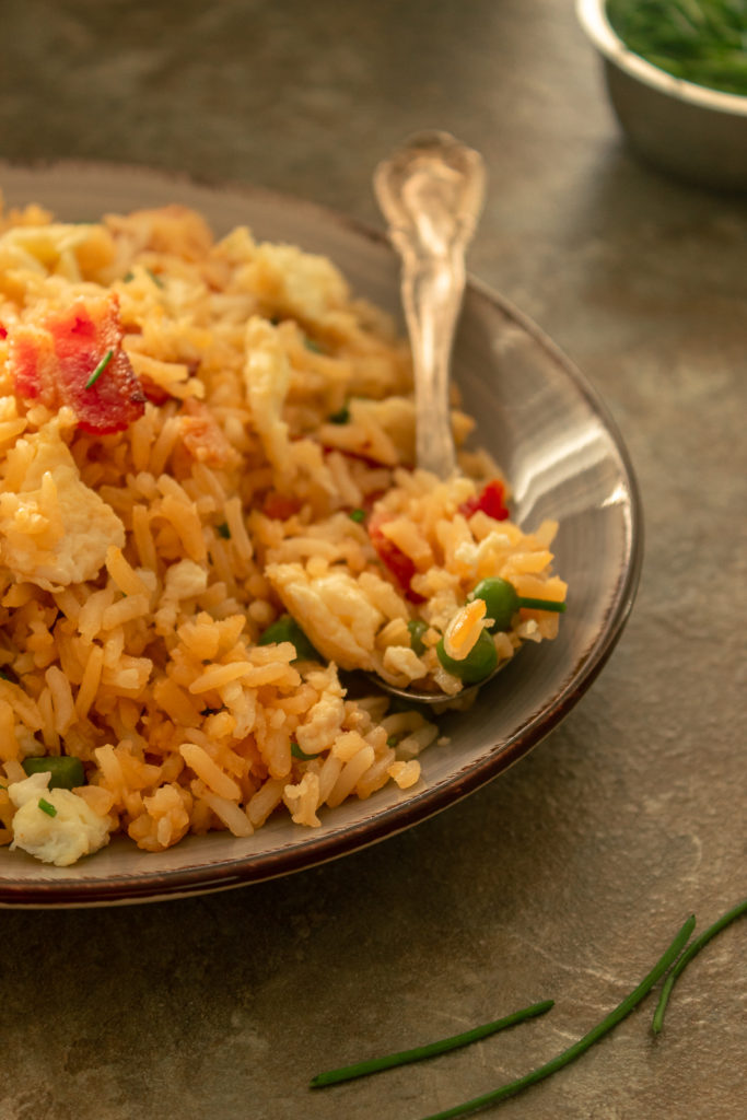 Fried rice on plate with spoon and green onions angled shot.