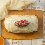 Overhead shot of Gluten-free orange cranberry bread with glaze and sugared cranberries on top.