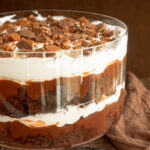 Death by Chocolate Trifle with Skor with brown background and wooden surface.