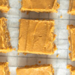 Overhead shot of Peanut butter squares on parchment on wire rack.