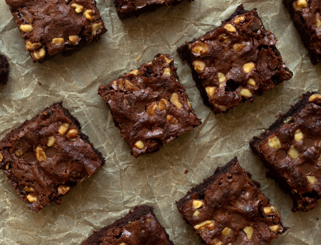 Overhead shot of classic brownies cut up on parchment paper.