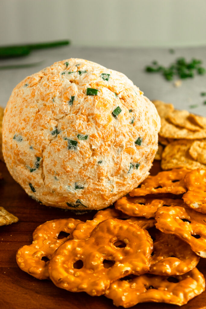 Cheese ball on wooden platter with crackers