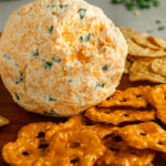 Cheese ball on wooden platter with crackers