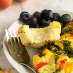 Angled shot of Easy Breakfast Egg muffins on plate with fork and bite shot.