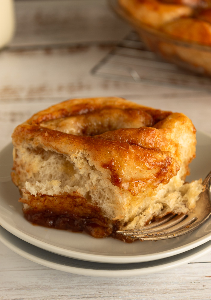 Old-fashioned cinnamon bun on plate with fork.