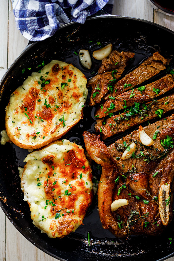 Romantic dinner recipe for two: overhead shot of steak and potatoes in cast iron pan.