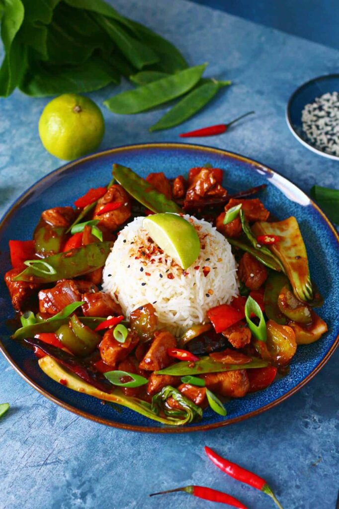 Romantic dinner recipe for two: wagamama firecracker chicken on blue plate with blue background.