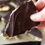 Hand holding up a piece of Healthy cookie dough bark.