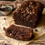 Angled shot of Double chocolate zucchini bread with a slice in front.